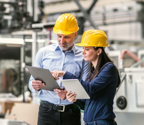 Photo of people with clipboards wearing hardhats